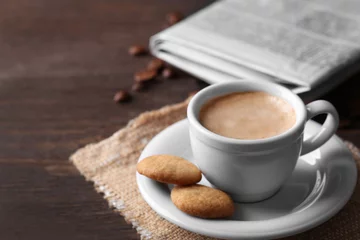 Fotobehang Cup of coffee, cookie and newspaper on wooden table background © Africa Studio