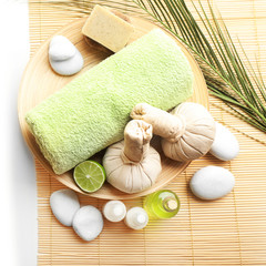 Obraz na płótnie Canvas Beautiful spa composition. Herbal balls and towel in the bowl. Pebbles and cosmetics close up
