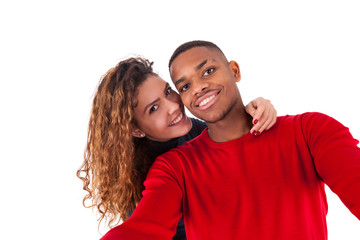 Happy mixed race couple taking a selfie photo over a white backg