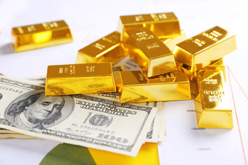 Gold bars with dollar banknotes on paper background