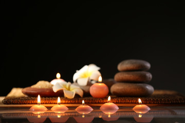 Spa still life with stones, candles and flowers in water