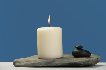 Fototapeta na wymiar Lit candle on a rock.