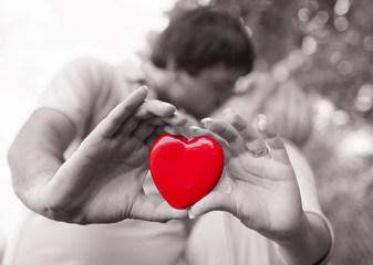 Obraz premium Couple kissing while holding a beautiful heart. 