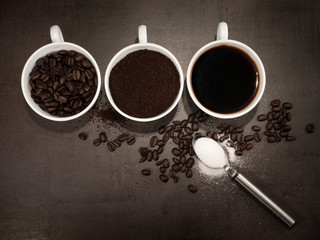 Top view of the steps in preparing a cup of fresh filter coffee from roasted coffee beans with sugar on dark vintage background