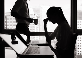 Silhouettes of stressed business woman in the office.
