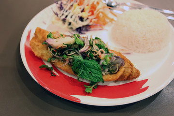 Salmon fried and jasmine rice on dish.