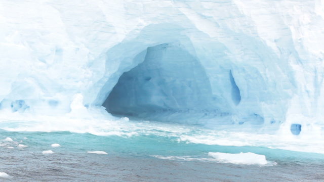 Waves crashing against large tabular iceberg formation in Drake Passage near Antarctica.