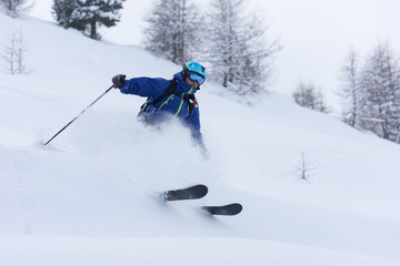 freeride skier skiing in deep powder snow