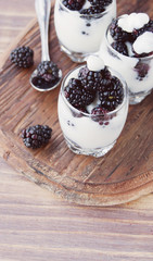 yogurt cup with blackberry on wooden table