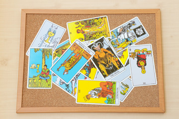 Fototapeta na wymiar Mix of tarot card on the cork board.