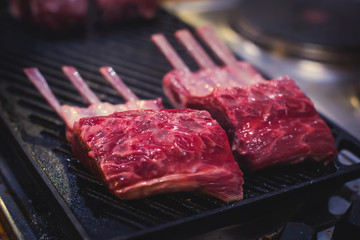 Different stages of cooking the steak on a kitchen, barbeque, roasted lamb ribs, big dish plate with roasted full pork head, served in restaurant with vegetables, lamb, ham and chicken.
