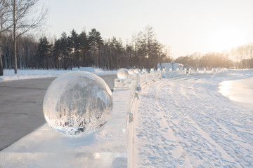Row of ice balls at sunset in winter