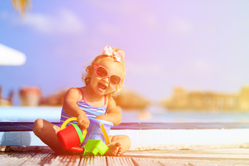 Obraz na płótnie Canvas cute little girl playing in swimming pool at beach