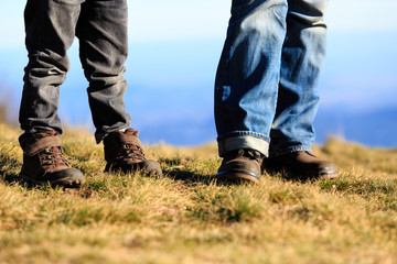 father and little son hiking boots in mountains