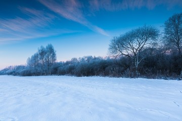 Beautiful cold morning on snowy winter countryside.