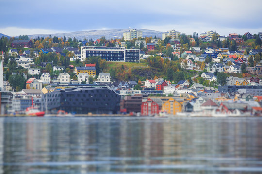 Beautiful super wide-angle panoramic aerial view of Tromso, Norway with harbor and skyline with scenery beyond the city, sunny summer day with blue sky
