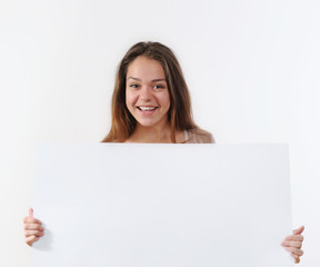 Fototapeta premium beautiful young woman holding a placard and smiling against a wh