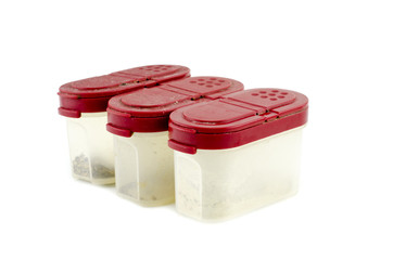 red cover and plastic box container with white pepper isolated white background