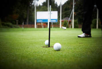 Golf player's legs on green field.