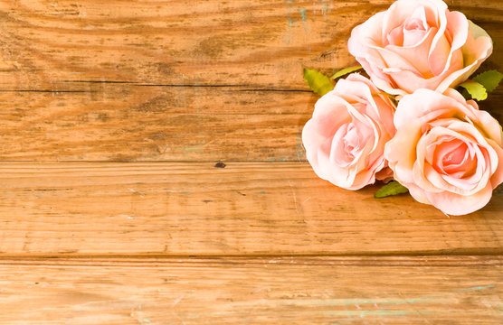 Roses on wooden boards, floral background for greeting card with copy-space