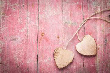 Two Wooden Hearts on Pink Background