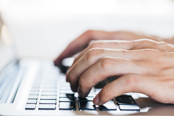 Close-up of hands typing on keyboard (Selective focus)