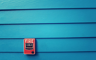 Fire alarm with blue painted wood background