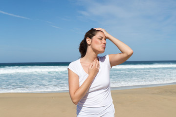 Fototapeta na wymiar Huebsche Frau mit Kopfschmerzen im Urlaub