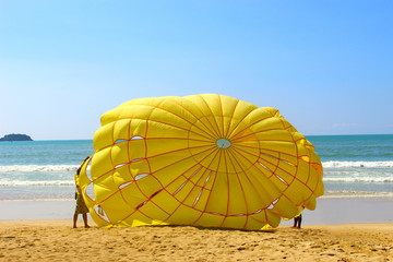 The yellow parachute on the beach on sunny day afternoon, selective focus on yellow parachute, the light shades from the left side