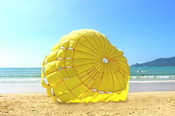The yellow parachute on the beach on sunny day afternoon, selective focus on yellow parachute, the light shades from the left side