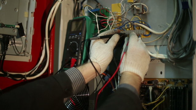 The scientist makes in the switchboard electrical measurements with a multimeter
