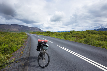 Fototapeta premium Biker rides on road at sunny summer day in Iceland
