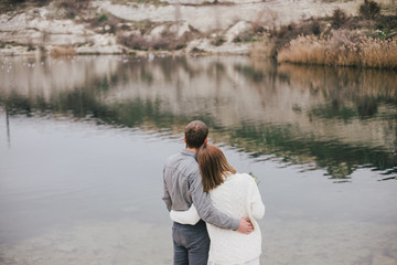 Winter wedding. Beautiful young couple posing near lake