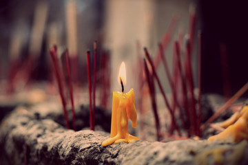 The lighted candle on joss stick pot, selected focus on the candle