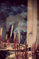 The joss stick in joss, stick pot, selective focus on the middle joss stick with the smoke