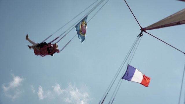 Swing Ride People, French Flag - 60fps. The Fete foraine du Jardin des Tuileries is a small amusement park that is set up every summer in the Tuileries Gardens in Paris