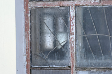 Old frosted window of an abandoned building in winter. 