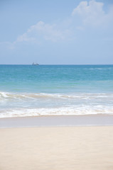 A boat sailing in the clear blue waters of the Indian Ocean on a bright sunny day in Sri Lanka