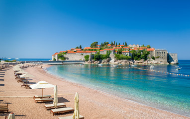 Sveti Stefan luxury sand beach with chaise-longue chairs and umbrellas - obrazy, fototapety, plakaty