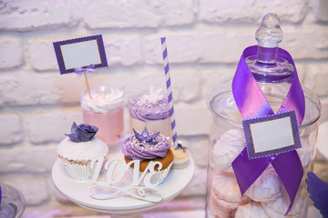 Candy bar. Table with sweet 
candies, purple light at background