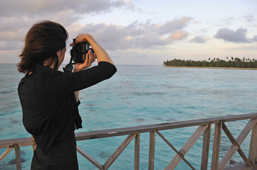 Woman taking a photograph of a tropical island, Borneo, Sabah State, Malaysia, Southeast Asia