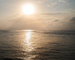 Scenic morning seascape. Sun rising over the sea.  Bright reflection in the water.