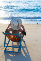 Woman sitting on the lounge chair at the beach