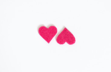 two pink felt hearts on white background