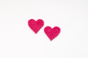 two pink felt hearts on white background