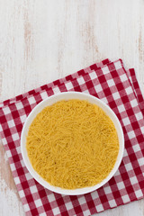 pasta on white bowl on napkin on white wooden background