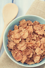 cereals in blue bowl on white wooden background