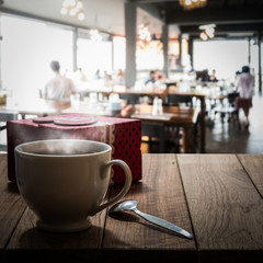Hot coffee and gift box on wooden table