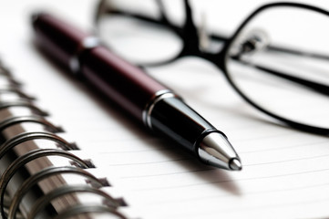 Pen and Eyeglasses on Spiral Notebook