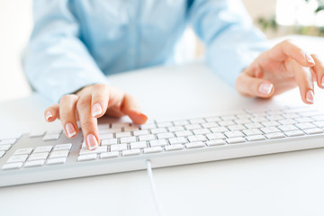 Woman office worker typing on the keyboard